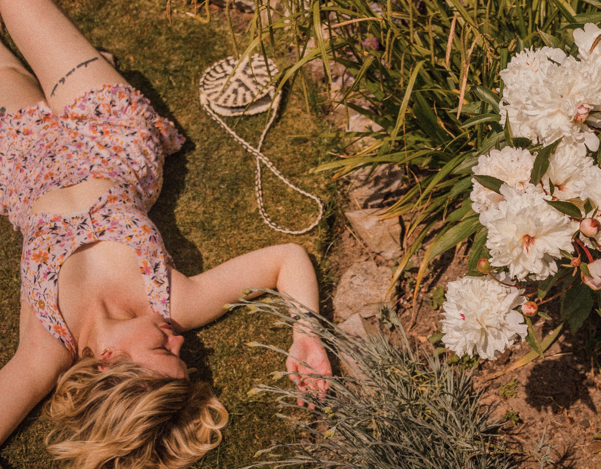 blonde girl in garden wearing floral playsuit - summer bucket list