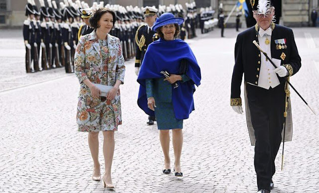 Queen Silvia wore a blue outfit. First Lady Jenni Haukio wore a floral print outfit