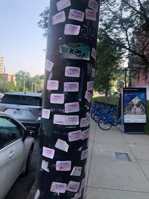 Pole covered with "Visitor/Void" stickers, taken July 27, 2021