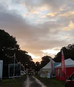 6am Saturday morning Just So Festival 2019 rain puddles, wristband exchange and cloud filled sky with pink tinge