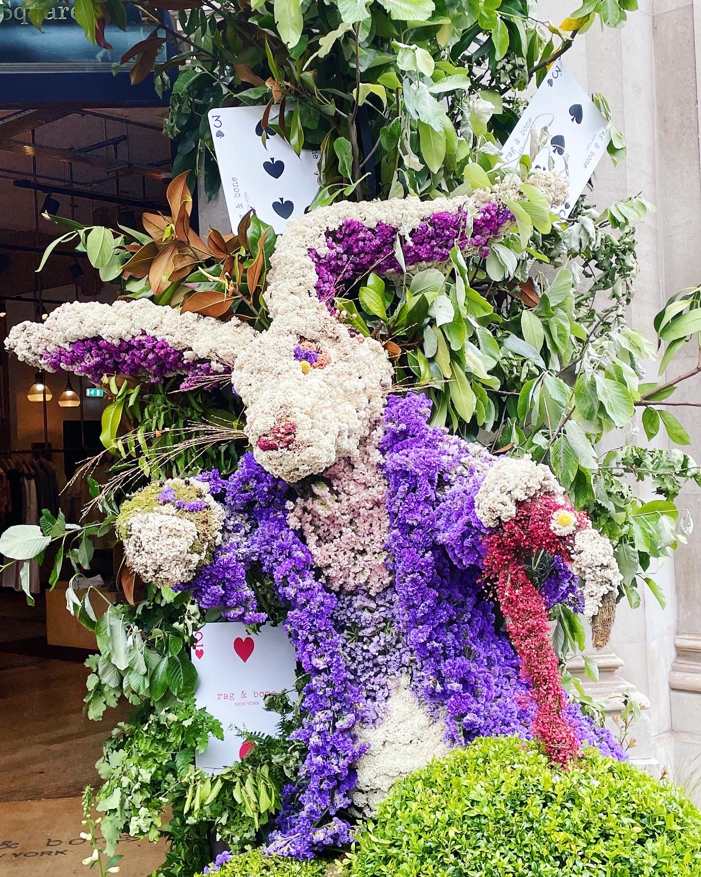 Rabbit-shaped floral display (in the spirit of Alice in Wonderland) with large playing cards in the background.