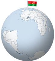 The Burkina Faso flag is waving on a flagpole rising from the globe.