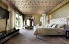 Large luxury master bedroom with king size bed and red flowers on the ceiling