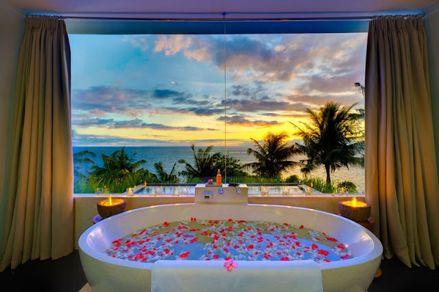 Picture of the bathtub by the window overlooking the sunset and the ocean