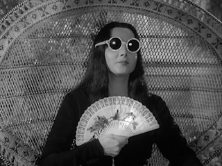 Morticia in sunglasses with fan