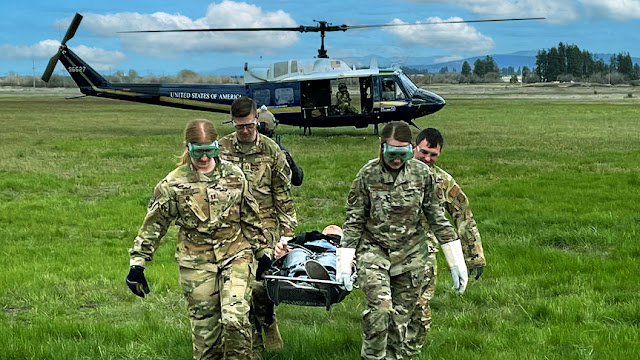 A group of Air Force service members carries a patient on a stretcher.