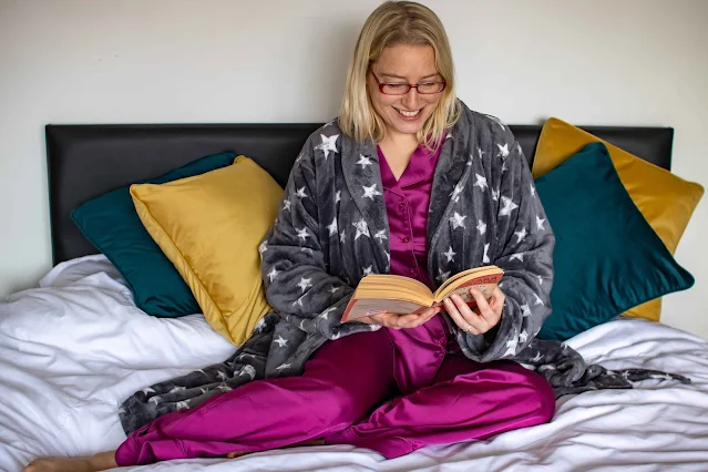 Me reading a book in bed with a beautiful pair of satin pjs and a cozy dressing gown on