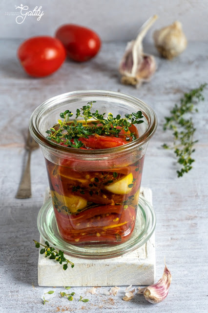 pieczone pomidory w szklanym słoiku z oliwą
