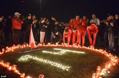 Dinamo Bucharest players light candles along with supporters after Ekeng died