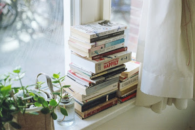 Pile of books on a sunny windowsill