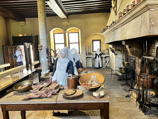 foto da recriação do ambiente da cozinha. Mostrando três manequins como três freiras, utensílios de cortar e cozinhar, mesa de preparação, ...,.