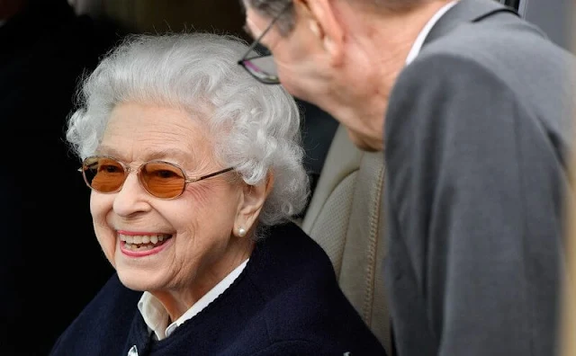 Queen Elizabeth wore a white blouse and a blue cardigan-style top and wearing sunglasses. The Duke and Duchess of Cambridge