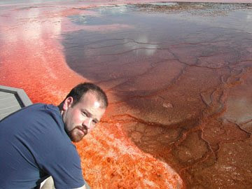 Keith at Yellowstone National Park, above a pool of orange acid