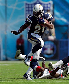 LaDanian Tomlinson does a near perfect Heisman pose while carrying the ball against the Texans