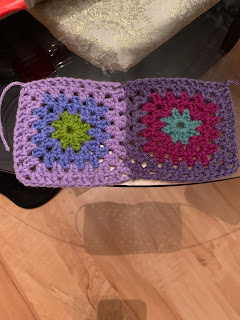 The previously shown square is on the left of a pair of joined granny squares. The one on the right is (center to outer) 1 round of sage, 2 rounds of boysenberry (raspberry pink), & 2 rounds of violet (dark lavender).