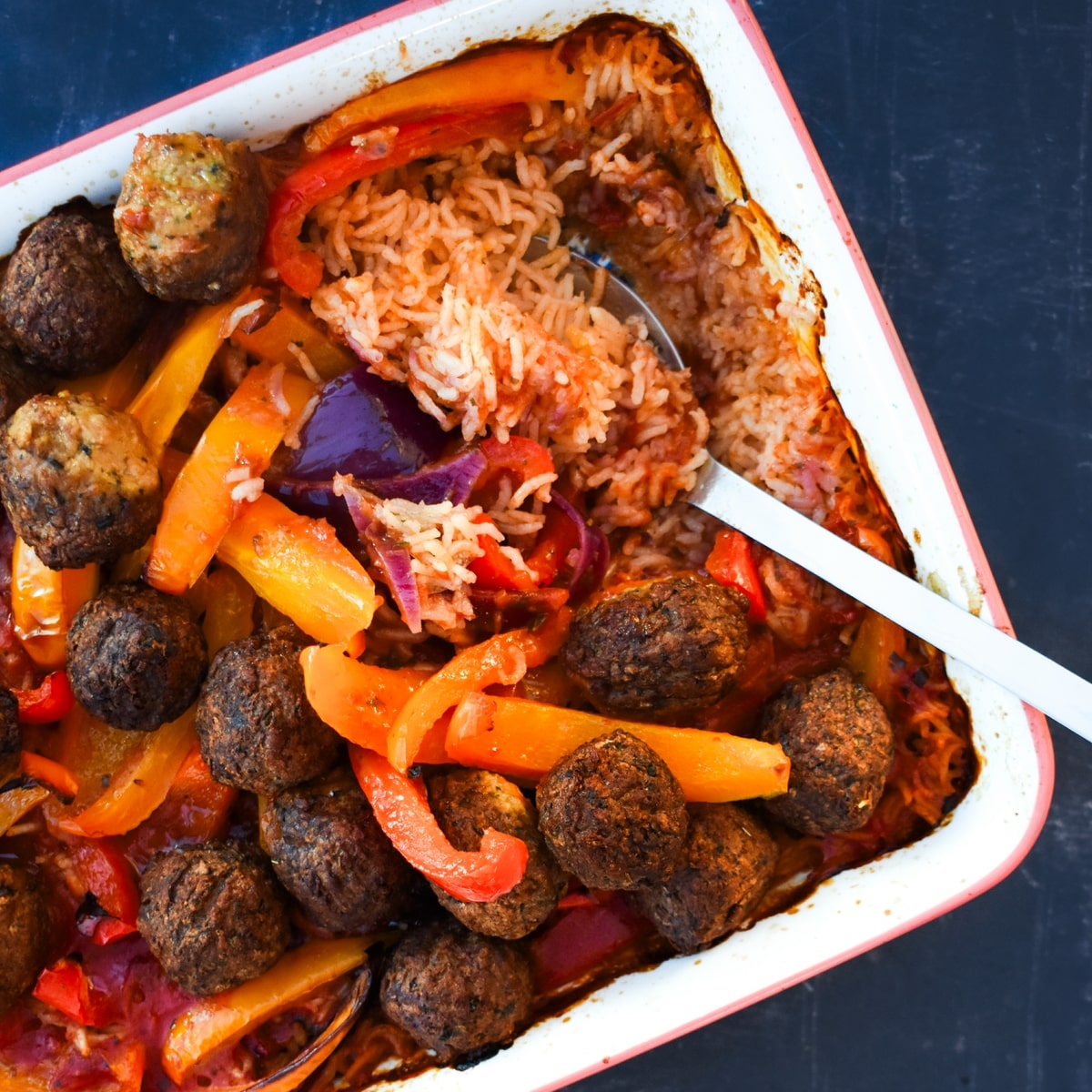 vegan meatball rice dish with a serving spoon.