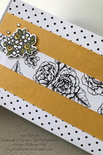 Giftbox wrapped in white paper with black spots, decorated with strips of yellow card and more patterned paper with black and white flowers. A handstamped and coloured image of a posy of daisies and roses embellishes the box along with some rhinestones