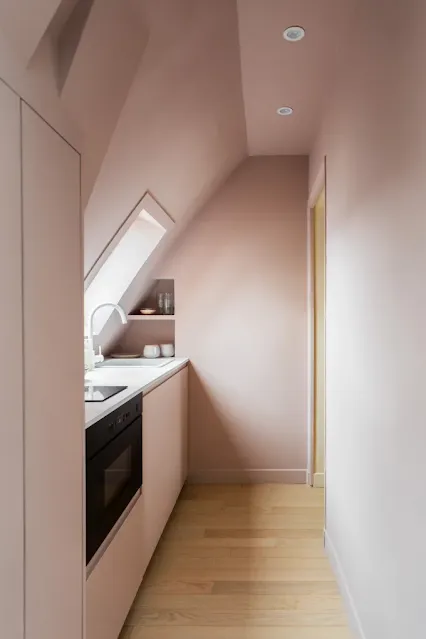 A modern pink kitchen arranged under the roof