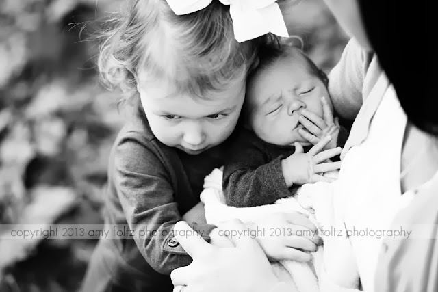 black and white photo of toddler and newborn