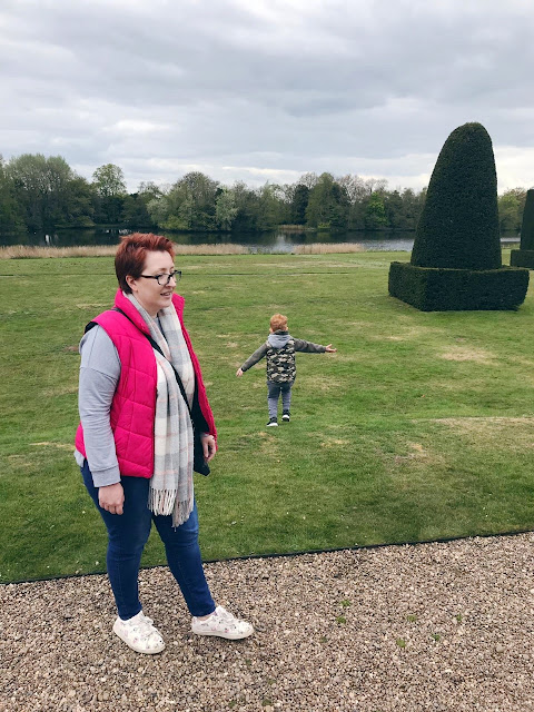 Mother at the front of a picture with a little boy running off in the background