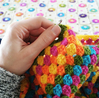 close up of hand crocheting a granny square