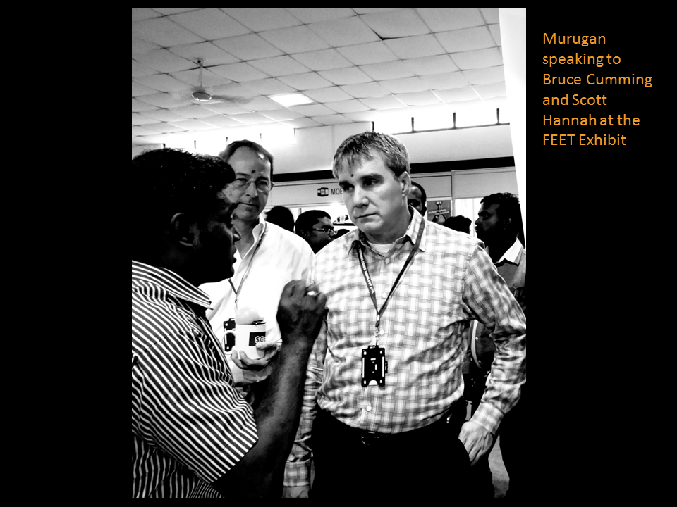 Murugan speaking to Bruce Cumming and Scott Hannah at the FEET Exhibit