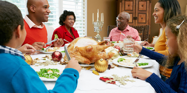 A family gathers around a table in a pre-Covid era.