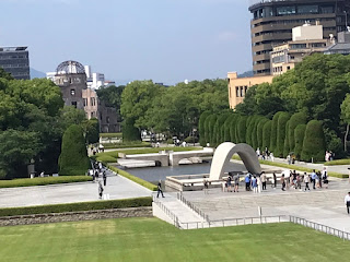 広い平和記念公園のモニュメントから遠巻きに原爆ドームがみえる