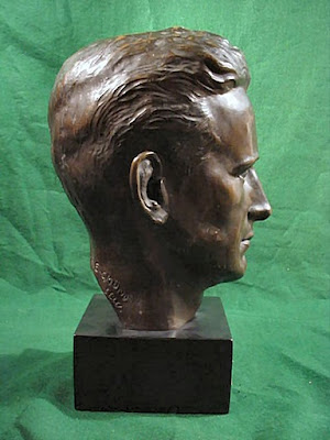 Bronze sculpture of a man's head in the profile view.