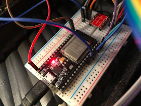 an ESP32 prototype board and a small red level-shifter board on a breadboard, with jumper wires running all over the place