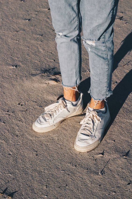 Calça Jeans Masculina com Barra Cortada Desfiada e Tênis Branco