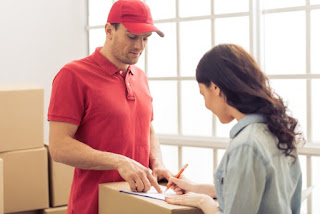 Young woman and delivery worker signing documents