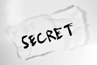 White paper with the word Secret written on it in black ink
