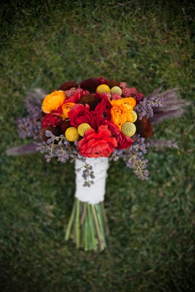 the bridal bouquet was made up of red yellow navy flowers ranunculas 