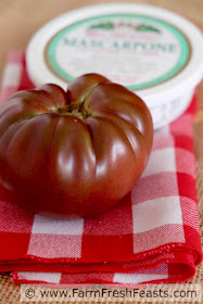 an heirloom tomato and a tub of mascarpone cheese