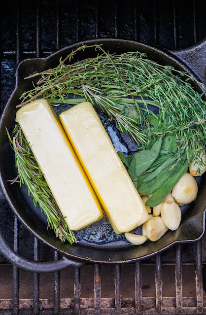 butter, garlic and herbs in a cast iron skillet on a smoker rack.