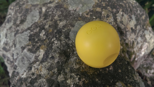 A Lemon drop EOS lip balm closed and on a rock