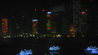 Image of a neon-lit 'Chinese Junk' transformed into a ghostly white junk on the water for the opening of the 2009 East Asian Games in Hong Kong