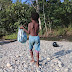 Seorang Anak Sedang Mengangkat Sampah Pelastik di Kali Jodoh, Tambrauw