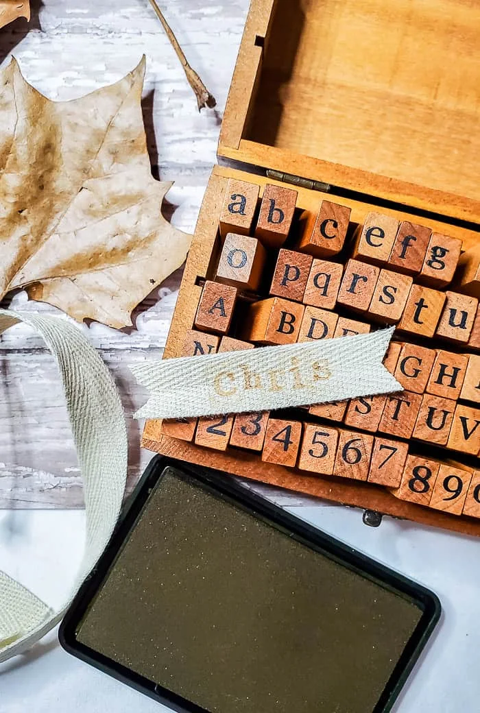 leaves, alphabet stamps and twill ribbon pieces with notched ends