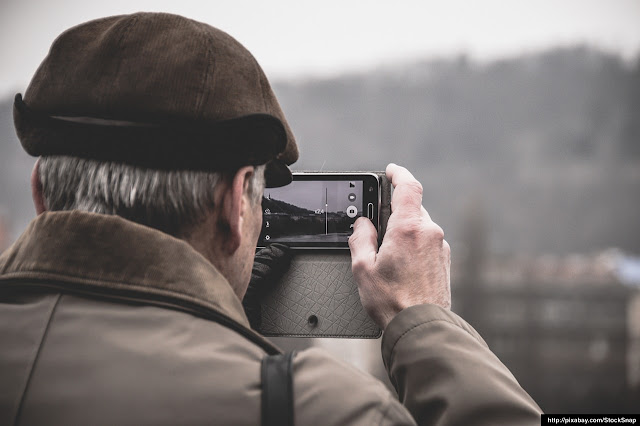 Varón tomando una fotografía con su teléfono