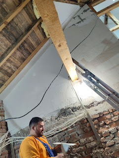 Halil plastering the high wall