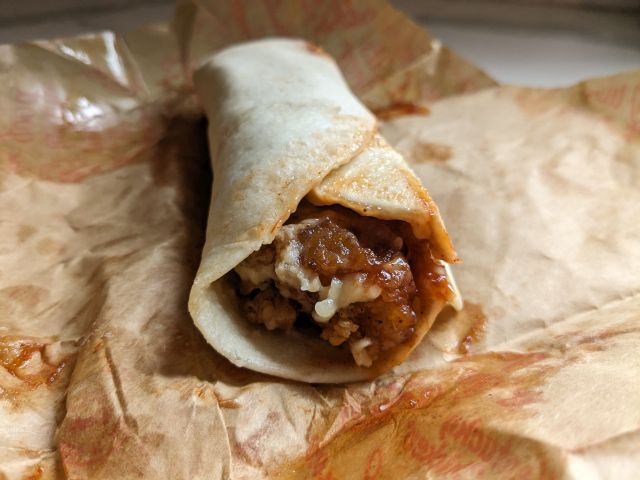 A close-up of the open end of a Honey BBQ KFC Wrap.