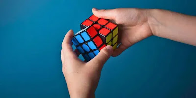 A person holding a Rubik's Cube with the first two layers solved, demonstrating the importance of F2L algorithms - Conquer the Cube: Mastering F2L Algorithms for Rubik's Cube