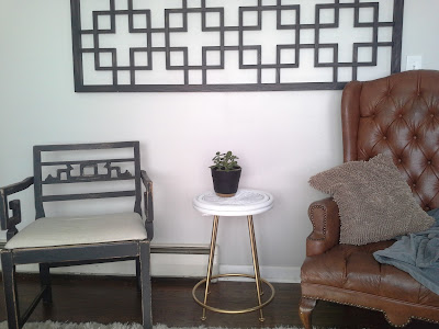 gold brass metal white wicker bamboo rattan side end table, charging station jade plant, greek key black chair, wing back tufted leather chair