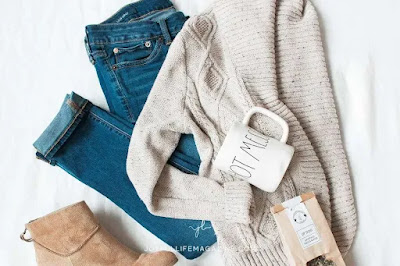 “Flat lay of casual capsule wardrobe pieces with jeans, sneakers, and accessories arranged neatly”