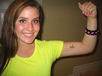 Julie with a gun tattoo. Get it---big "guns" (rub on tattoo)