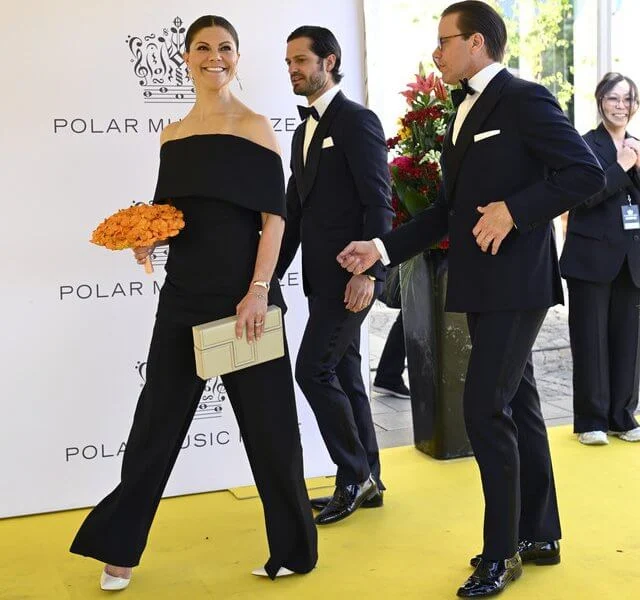 Queen Silvia wore a python print dress. Crown Princess Victoria wore a black open-back silk top and pants. Diamond earrings