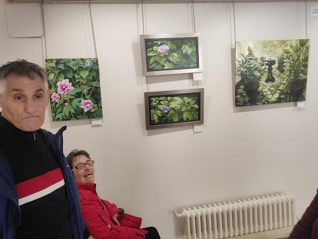 Dos personas mirando una exposición de cuadros