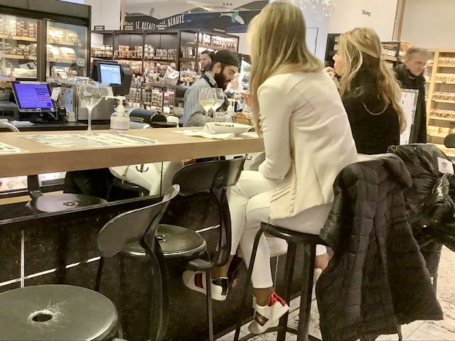 Woman in white suit eating at a counter